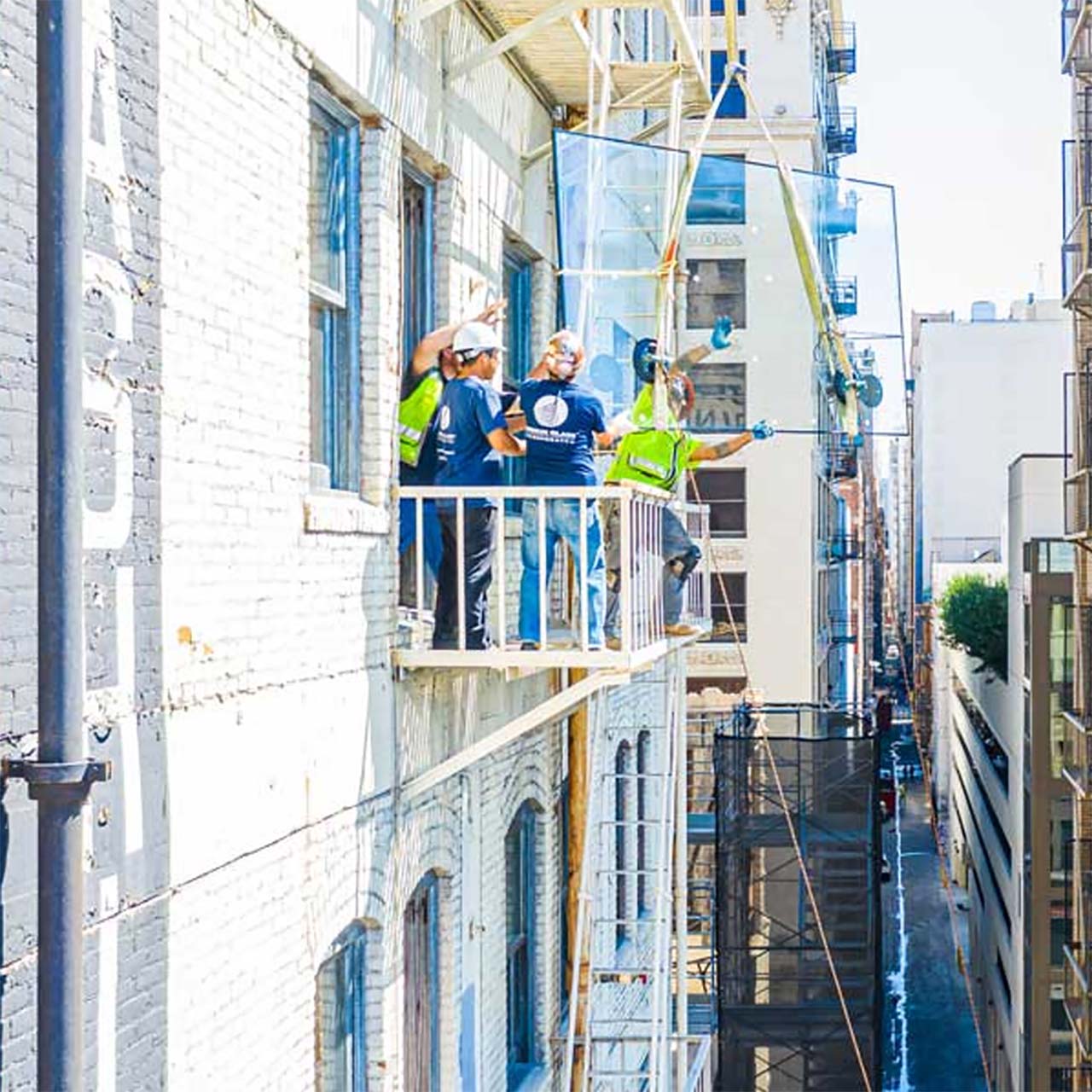 men installing large pane of glass while standing on balcony